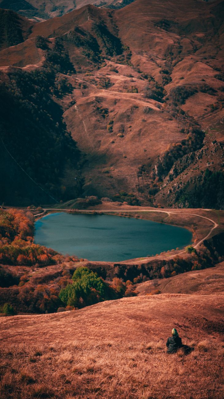 Expedition traveler viewing serene misty mountain lake